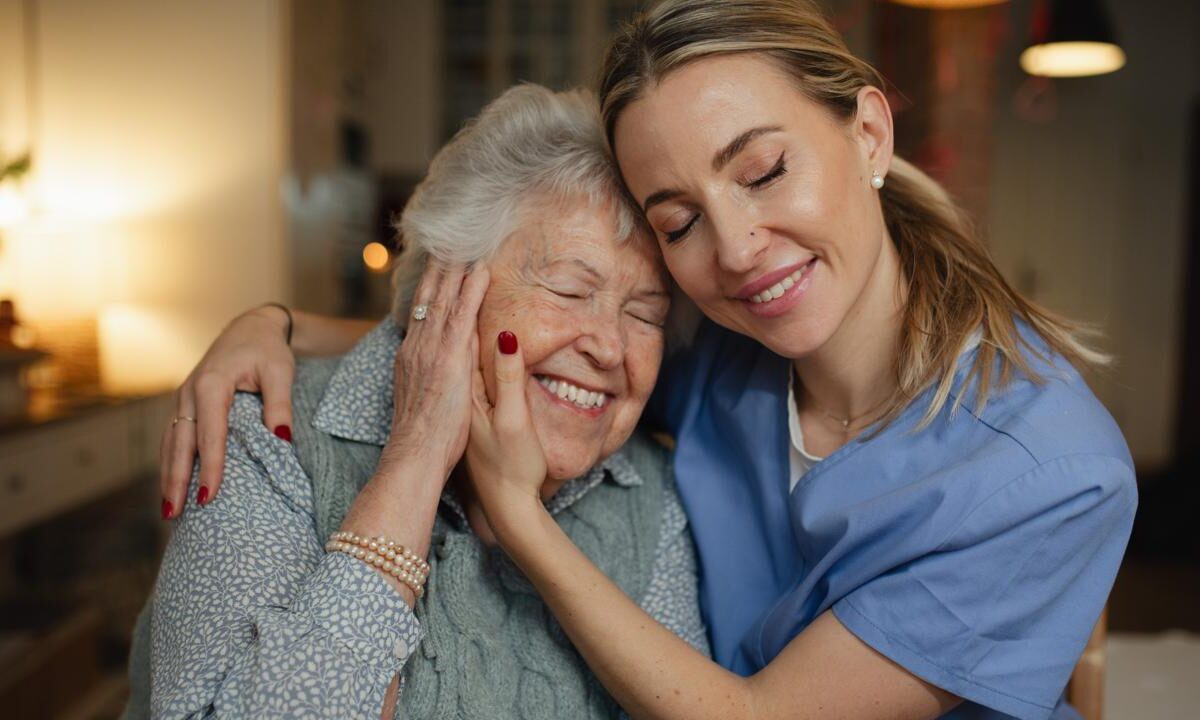 Caregiver and an older woman sharing a warm moment at home