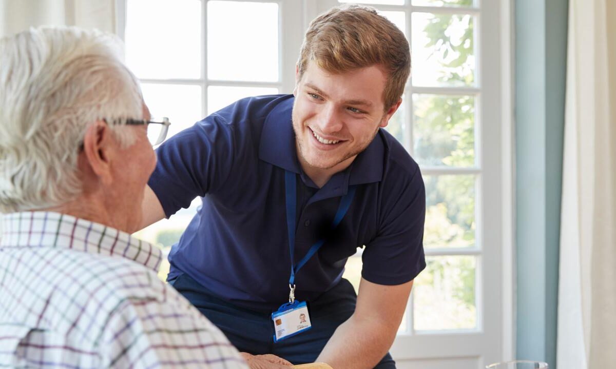 Caregiver greeting an older man at home